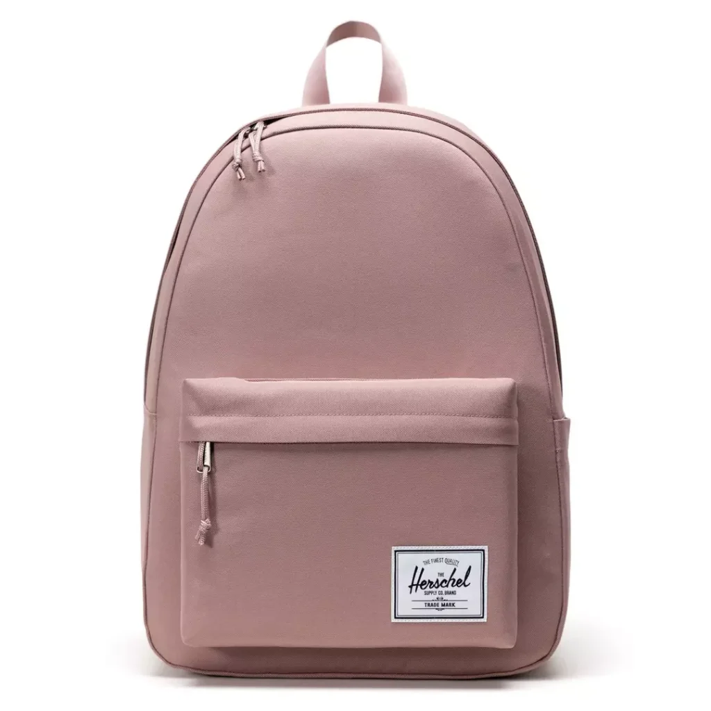pale pastel pink rounded top backpack with two-way zippers at the main compartment, a top loop carry handle and a lower-front zip pocket with a contrast white Herschel logo patch